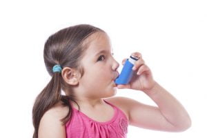 Flicka använder astmainhalator