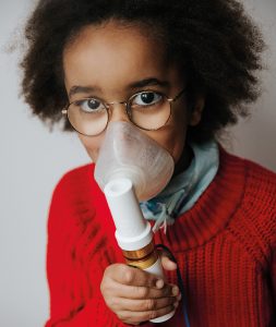 Amanda inhalerar astmamedicin med nebulisator med andningsmask