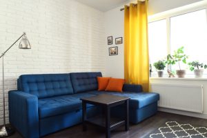 Vardagsrumsinteriör med soffa, soffbord, matta och fönster