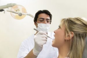 Tandläkare undersöker en kvinnas tänder