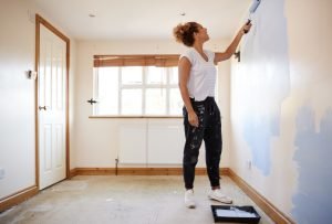 Kvinna målar vägg med roller