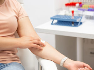 Kvinna håller tryck mot armvecket efter blodprov