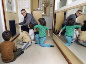 Stefan Lysén visar ventilationslucka för tre förskolebarn