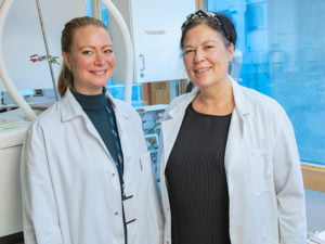 Forskarna Ulrika Nilsson och Josefine Carlsson i vita rockar i labbmiljö.