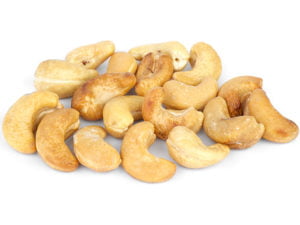 En hög rostade cashewnötter på vit bakgrund