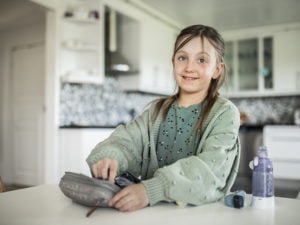 Sjuåriga Isabelle i köket med sin medicinväska